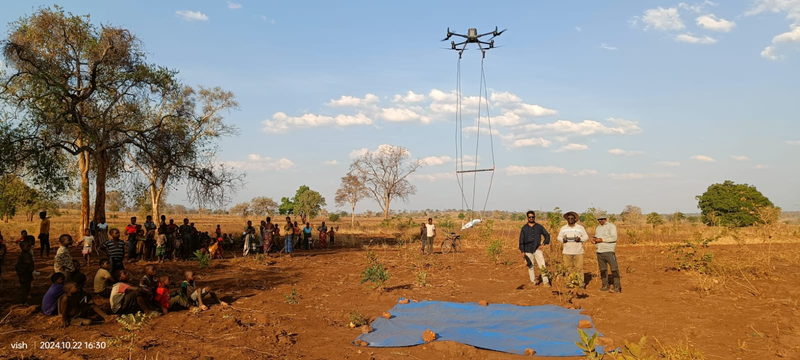 Drone lifting a magnetometer sensor loop over an open field